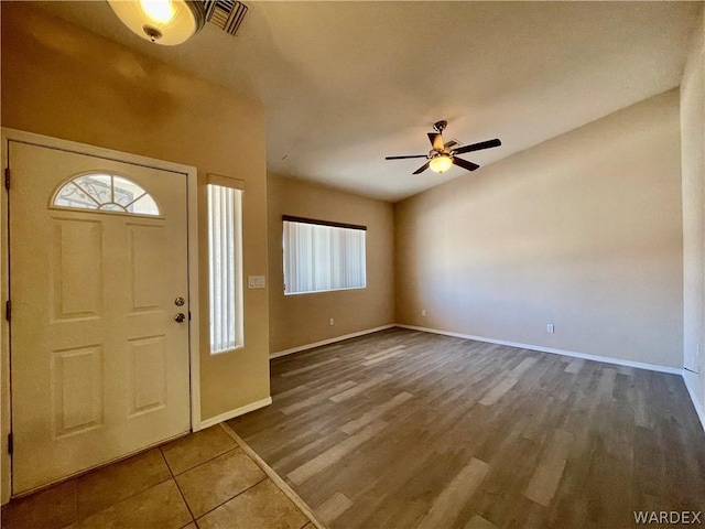 entrance foyer with a ceiling fan, visible vents, baseboards, and wood finished floors