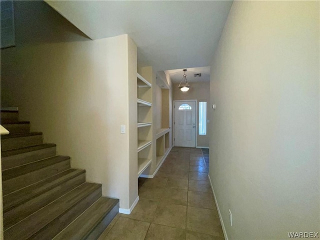 foyer entrance with stairway, tile patterned flooring, visible vents, and baseboards