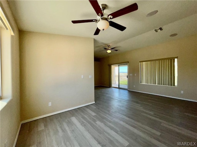 spare room with visible vents, baseboards, and wood finished floors