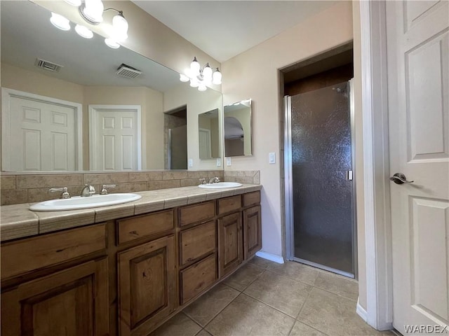 full bath featuring a stall shower, tile patterned flooring, a sink, and visible vents