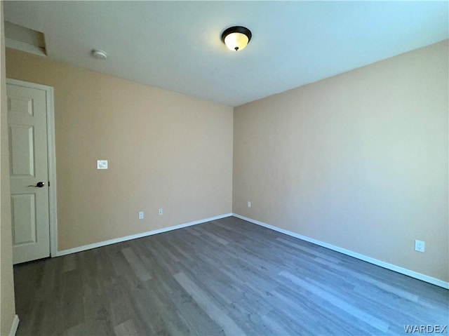 spare room with dark wood-style floors and baseboards