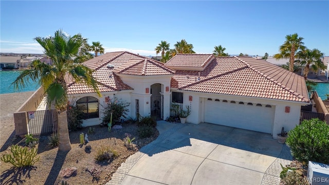 mediterranean / spanish home featuring driveway, a garage, a tile roof, fence, and stucco siding