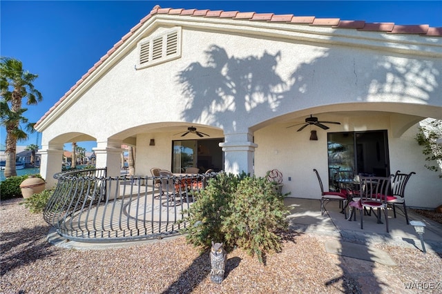 back of house featuring a tiled roof, a patio, a ceiling fan, and stucco siding