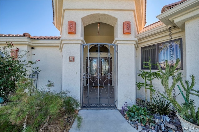 property entrance featuring a tile roof and stucco siding