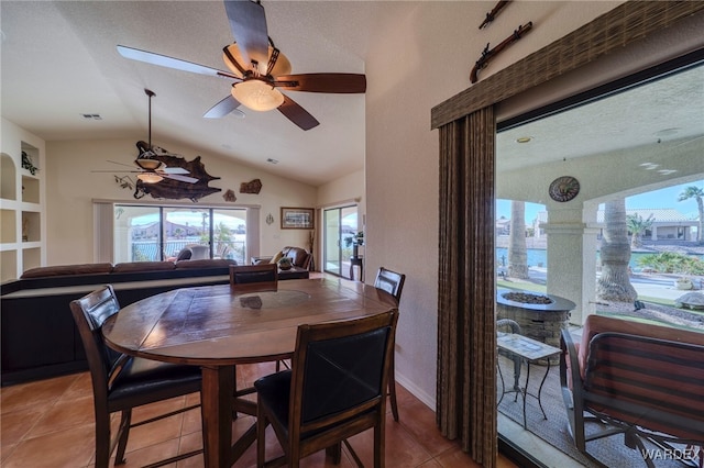 dining space with light tile patterned floors, visible vents, a ceiling fan, vaulted ceiling, and a textured ceiling