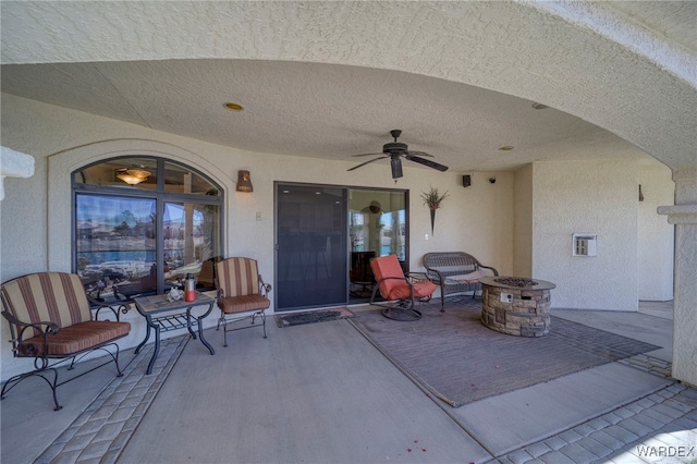 view of patio / terrace featuring ceiling fan and a fire pit