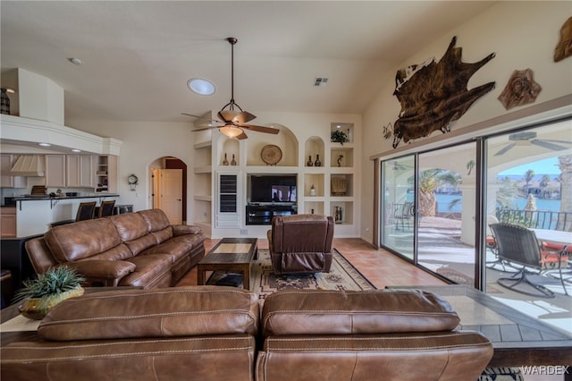 living room with visible vents, arched walkways, built in features, ceiling fan, and vaulted ceiling