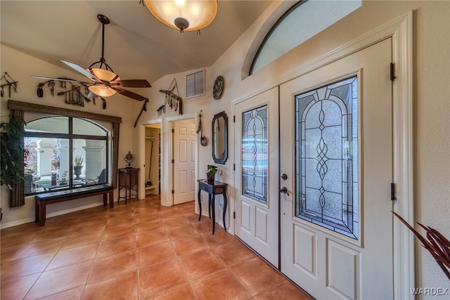 foyer entrance featuring lofted ceiling, light tile patterned floors, visible vents, and a ceiling fan