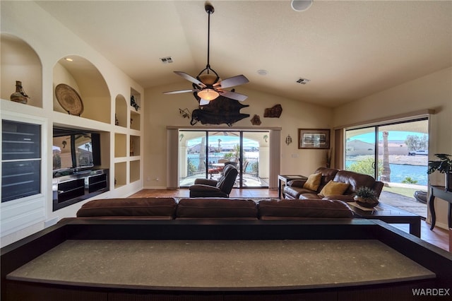 living room with visible vents, built in features, vaulted ceiling, and a wealth of natural light