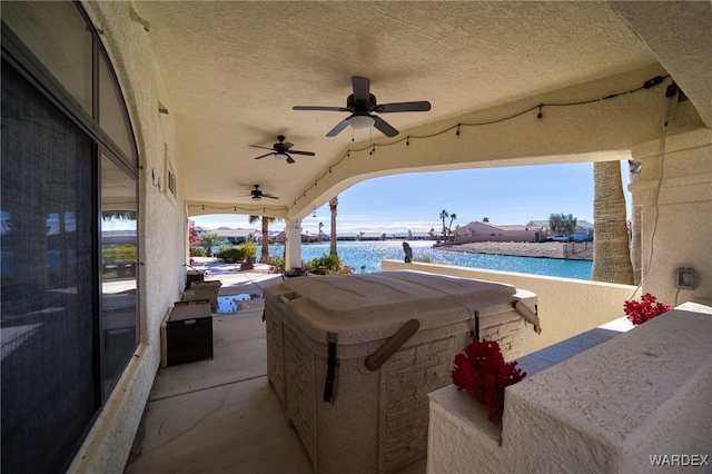 view of patio featuring ceiling fan and a water view