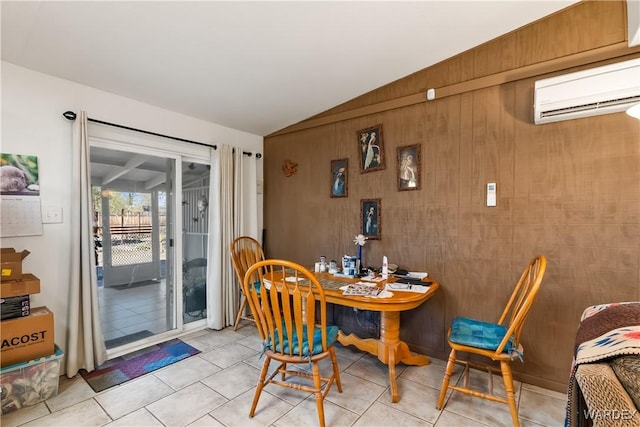 dining space featuring lofted ceiling, light tile patterned floors, wood walls, and a wall mounted AC