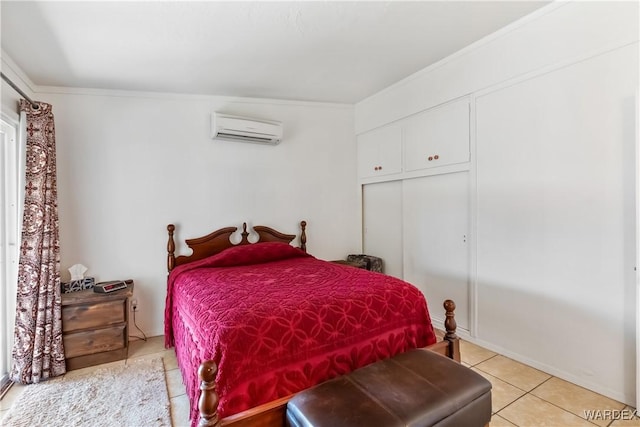 bedroom with a closet, light tile patterned floors, and a wall mounted AC