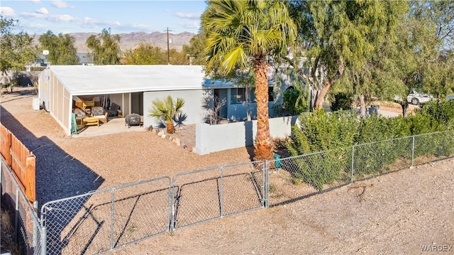 view of front of home with a mountain view, fence private yard, and a gate