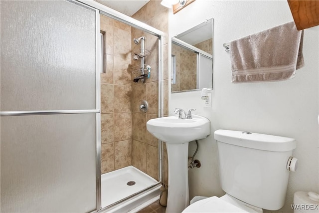 bathroom featuring a shower stall and toilet