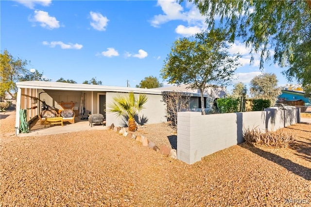 view of front of home featuring fence and a patio