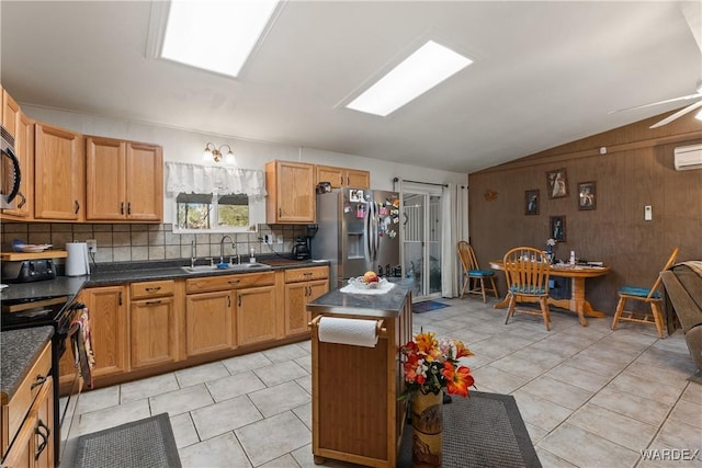 kitchen with decorative backsplash, dark countertops, lofted ceiling, stainless steel appliances, and a sink