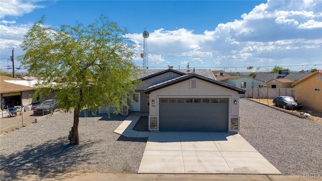 view of front of home with driveway, a tiled roof, an attached garage, fence, and stucco siding