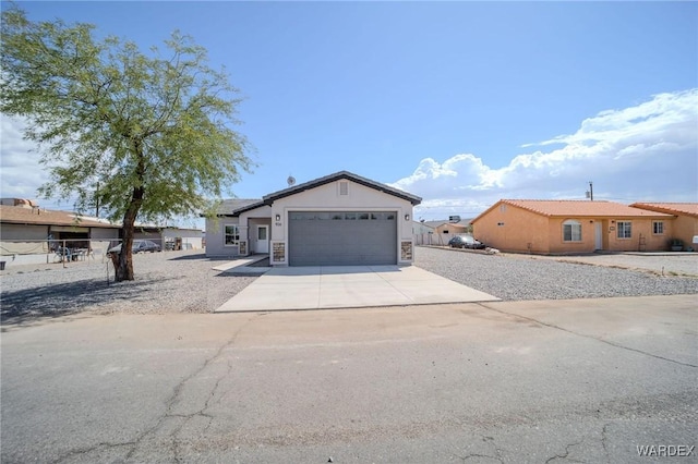 view of front of house featuring a garage, concrete driveway, and stucco siding