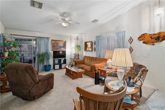 living area with light carpet, visible vents, vaulted ceiling, and a ceiling fan