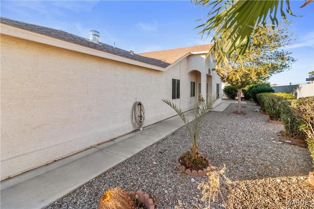 view of side of home featuring a patio and stucco siding