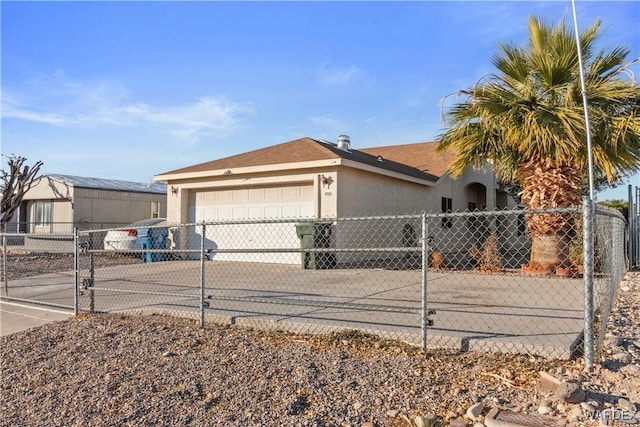 view of side of property with a garage, concrete driveway, fence, and stucco siding