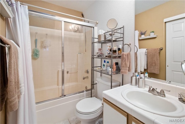 full bathroom featuring shower / bath combination with glass door, tile patterned flooring, vanity, and toilet