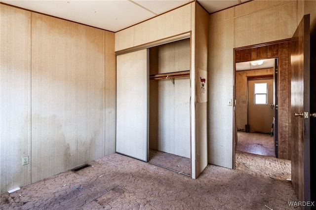 unfurnished bedroom with visible vents, carpet, and a closet