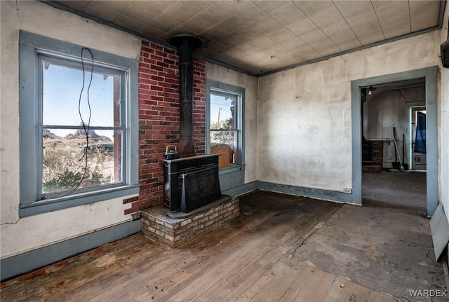 unfurnished living room featuring wood-type flooring and a wood stove