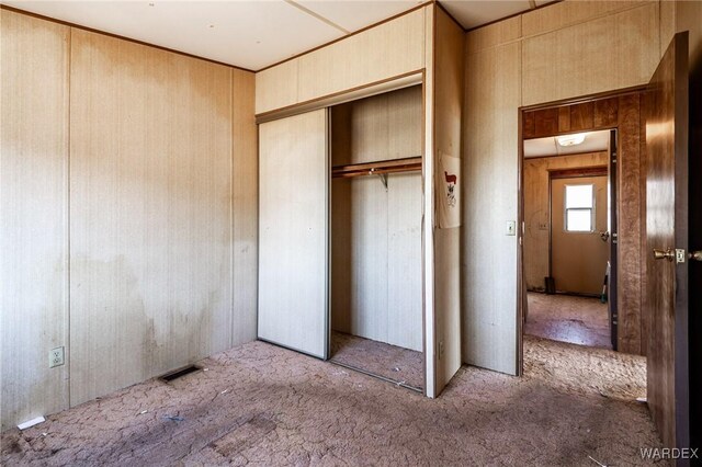 unfurnished bedroom featuring carpet, a closet, and visible vents