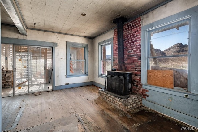 unfurnished living room featuring wood-type flooring and a wood stove