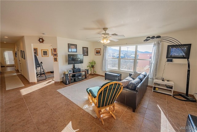 living area featuring a ceiling fan, baseboards, and tile patterned floors