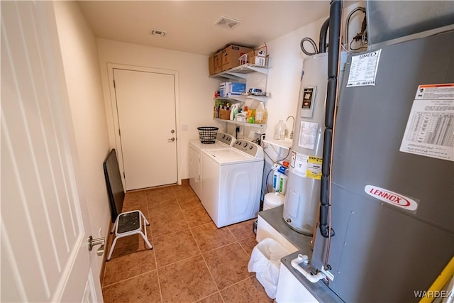 clothes washing area with laundry area, light tile patterned flooring, visible vents, and separate washer and dryer