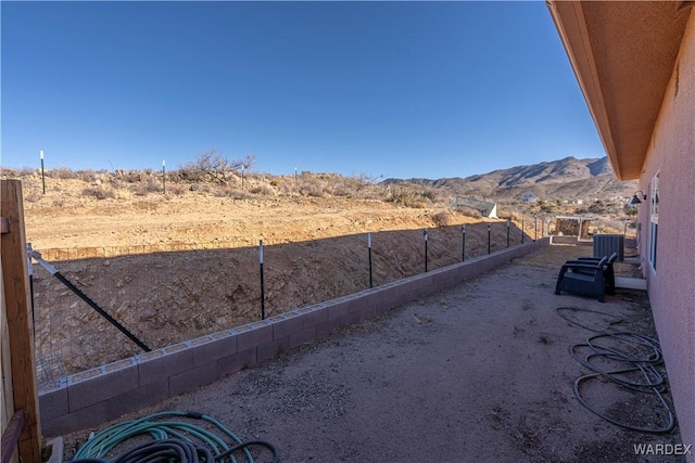 view of yard featuring fence and a mountain view