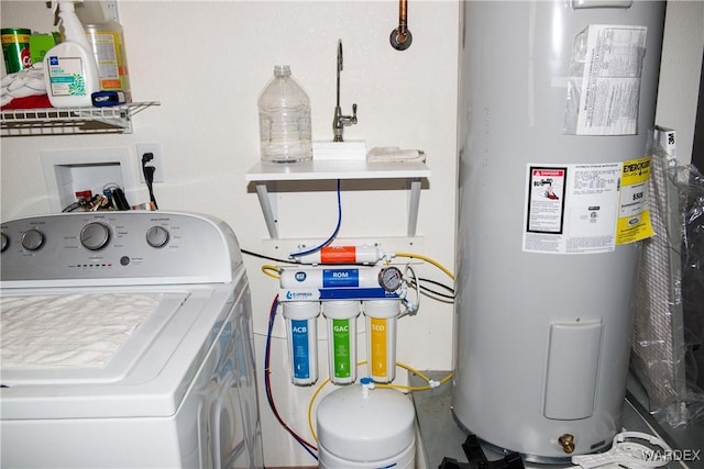 clothes washing area featuring washer / dryer, water heater, and laundry area