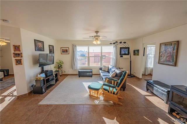 living room featuring a ceiling fan, tile patterned flooring, and baseboards