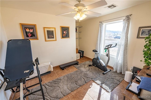 exercise room featuring tile patterned flooring, visible vents, ceiling fan, and baseboards