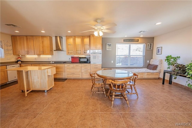 kitchen featuring white appliances, visible vents, light countertops, wall chimney range hood, and glass insert cabinets