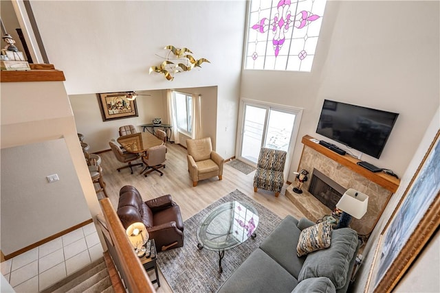 1800 Clubhouse Dr Unit D41, Bullhead City, AZ 86442 - living area with a fireplace, ceiling fan, a towering ceiling, baseboards, and wood finished floors