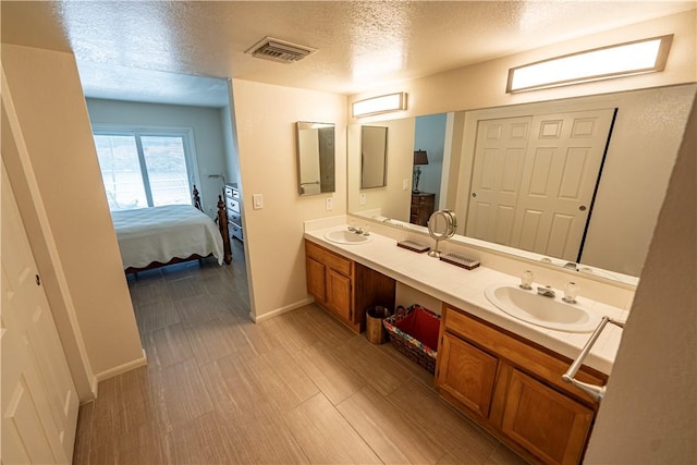 1800 Clubhouse Dr Unit D41, Bullhead City, AZ 86442 - ensuite bathroom with a textured ceiling, double vanity, and baseboards