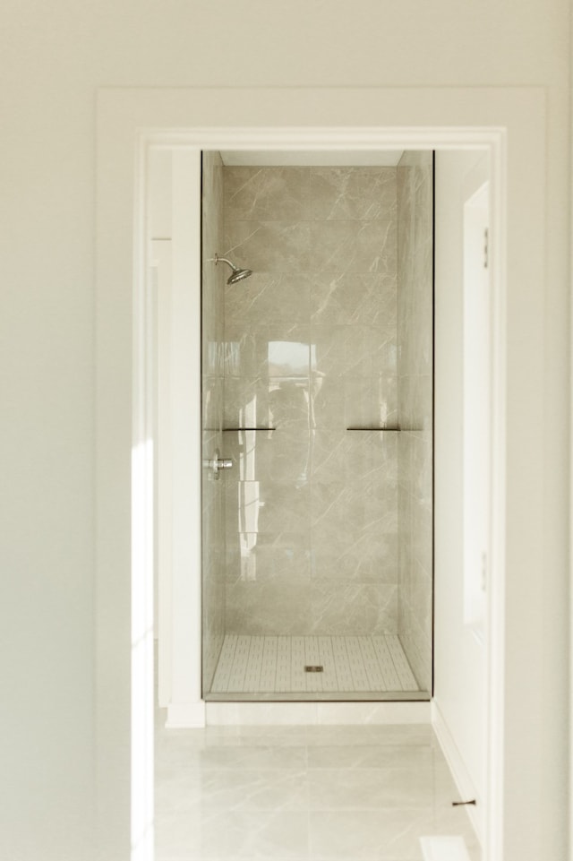 bathroom with tile patterned floors and tiled shower