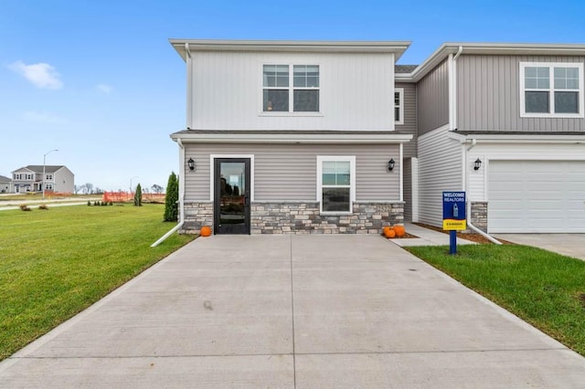 rear view of house featuring a garage and a lawn