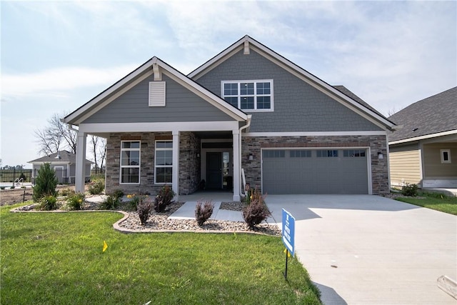 craftsman-style house featuring covered porch, a front yard, and a garage