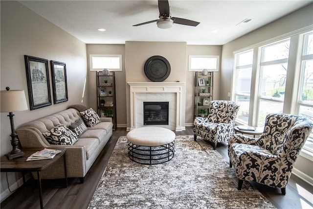 living room featuring ceiling fan, dark wood-type flooring, and a tile fireplace