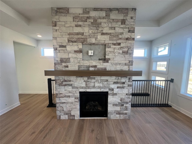 interior details with a stone fireplace and hardwood / wood-style floors