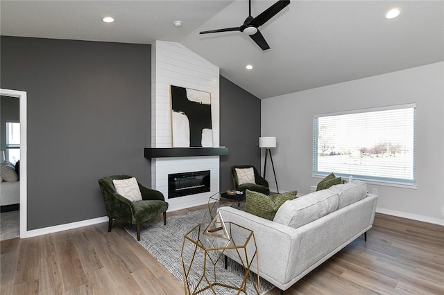 living room with ceiling fan, a fireplace, high vaulted ceiling, and wood-type flooring