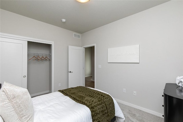 carpeted bedroom with a textured ceiling and a closet