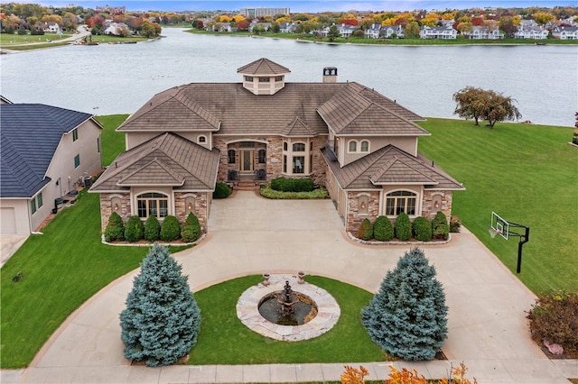 french country inspired facade with a front yard and a water view