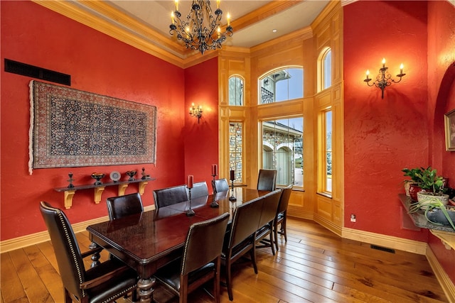 dining area featuring crown molding, hardwood / wood-style floors, and a notable chandelier