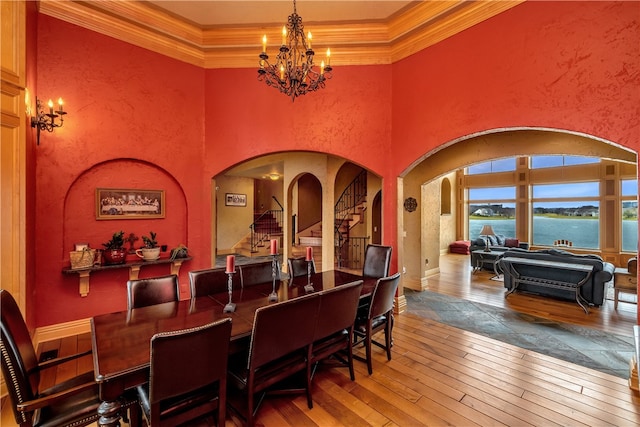 dining room featuring a high ceiling, an inviting chandelier, and hardwood / wood-style flooring