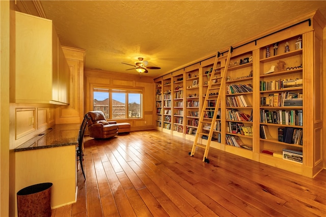 interior space featuring light hardwood / wood-style floors, a textured ceiling, and ceiling fan